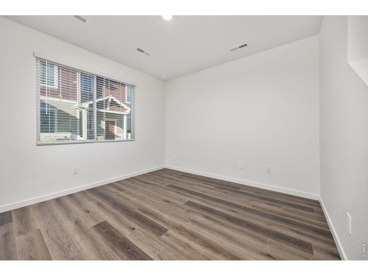 315 Condor Way Johnstown, CO 80534 - Photo 6 of 25 a view of an empty room with wooden floor and a window