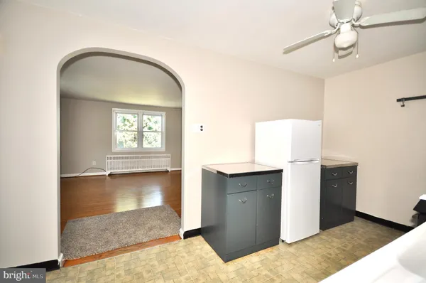 a view of a livingroom with wooden floor and a ceiling fan