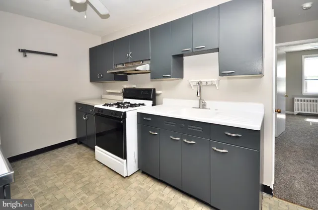 a kitchen with stainless steel appliances a sink a stove a microwave a refrigerator a counter top space and cabinets