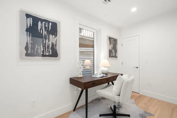 a view of a workspace with furniture and wooden floor