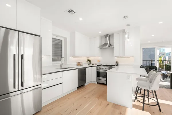 a kitchen with white cabinets and stainless steel appliances