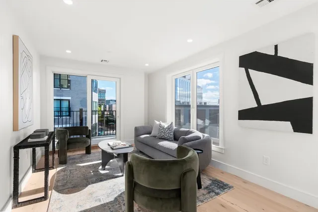 a living room with furniture and floor to ceiling windows