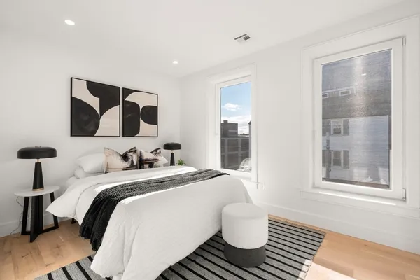 a bedroom with a bed and wooden floor
