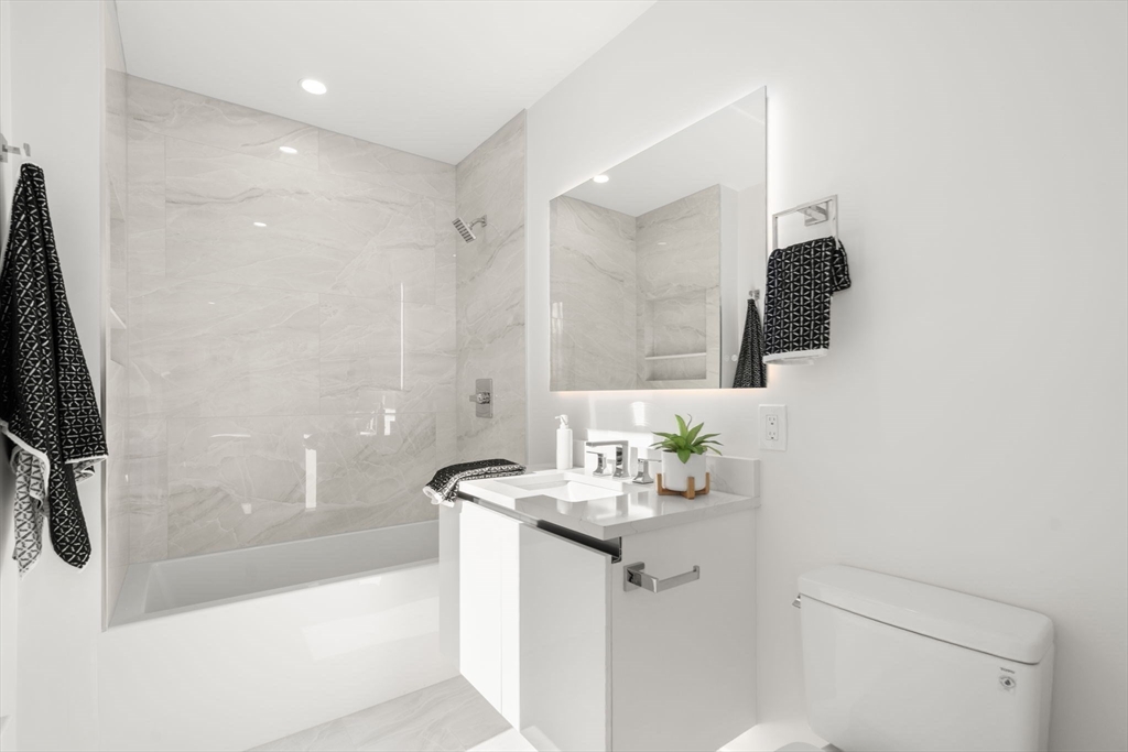 90 A Street, Unit 3 Boston, MA 02127 - Photo 10 of 20 a bathroom with a sink a mirror and a bathtub