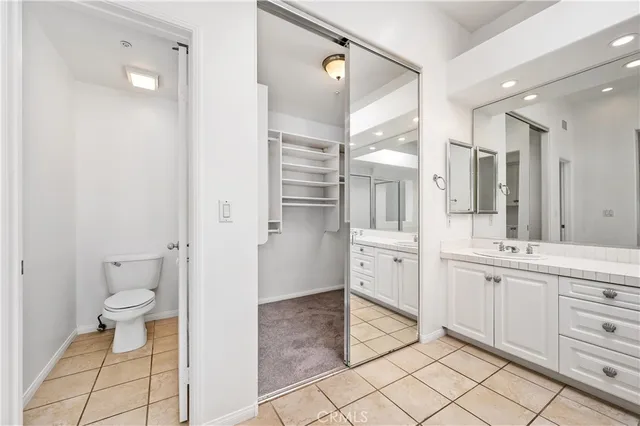 a spacious bathroom with a double vanity sink a toilet and a shower