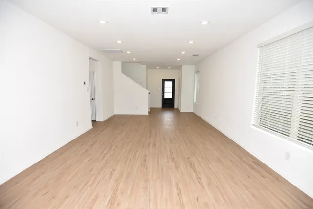 a view of a big room with wooden floor and windows