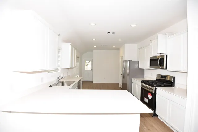 a kitchen with stainless steel appliances kitchen island sink refrigerator and stove