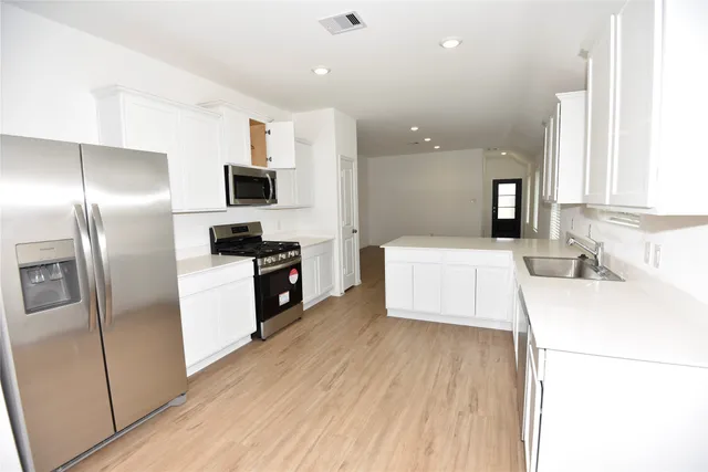a kitchen with a refrigerator and a sink