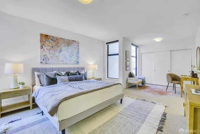 a spacious bedroom with a bed a table and chair