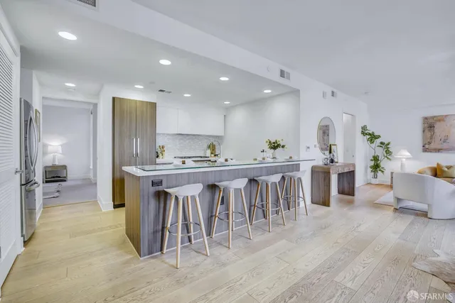 a kitchen with kitchen island granite countertop a sink and refrigerator