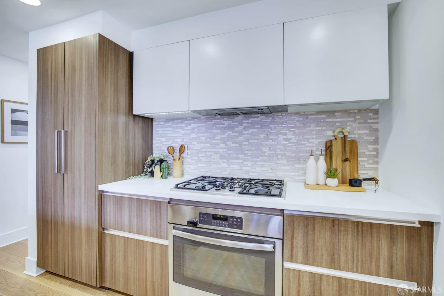 1080 Sutter Street, Unit 702 San Francisco, CA 94109 - Photo 9 of 27 a kitchen with stainless steel appliances granite countertop a stove and a refrigerator