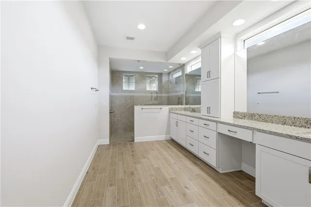 a large white kitchen with a sink a refrigerator and window