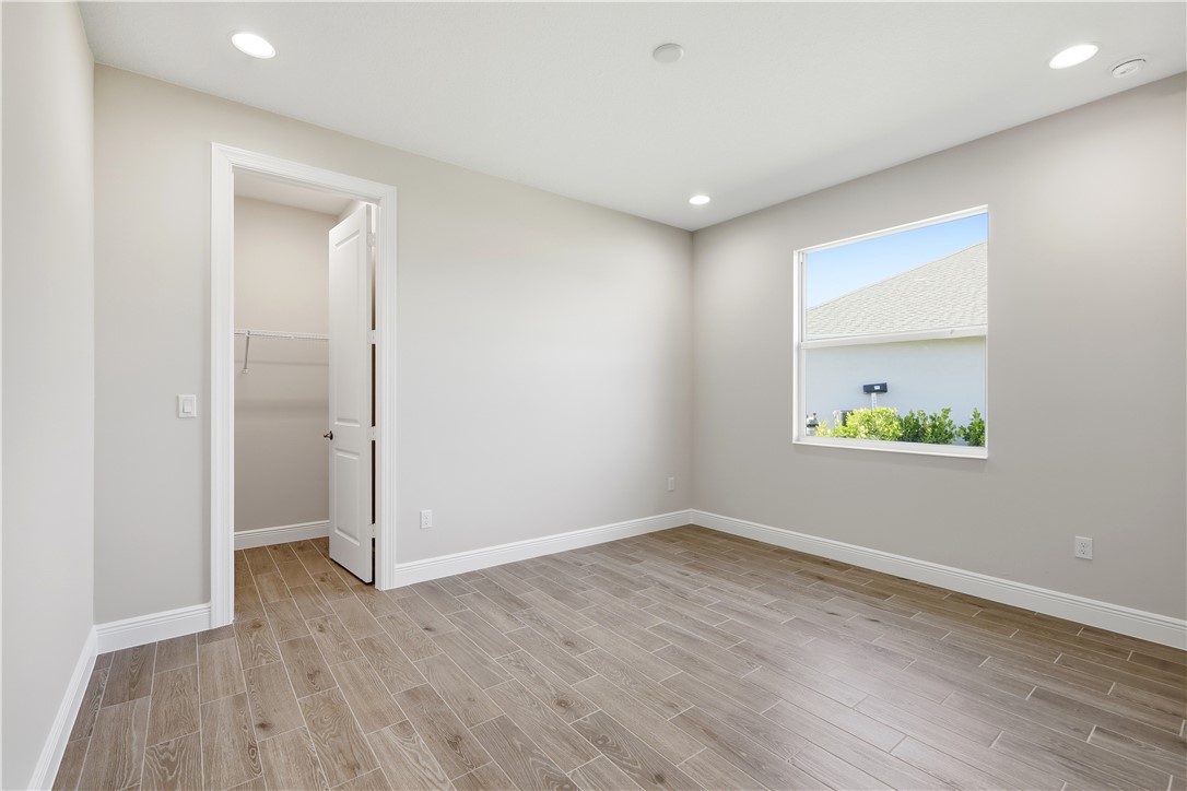 6304 High Pointe Circle Vero Beach, FL 32967 - Photo 16 of 25 an empty room with wooden floor and window