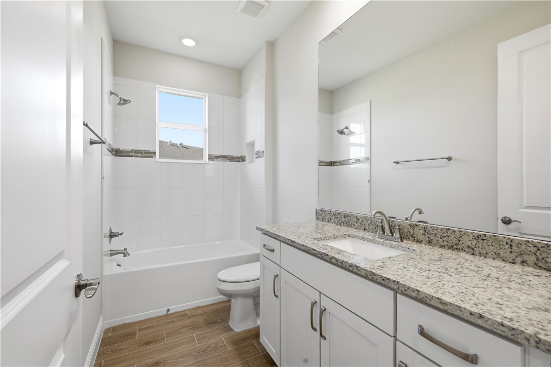 6304 High Pointe Circle Vero Beach, FL 32967 - Photo 17 of 25 a bathroom with a granite countertop sink a toilet and bathtub