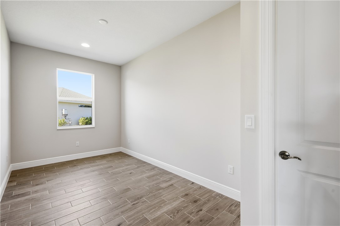 6304 High Pointe Circle Vero Beach, FL 32967 - Photo 20 of 25 an empty room with wooden floor and window