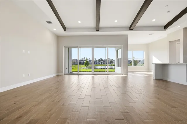 an empty room with wooden floor and outdoor view