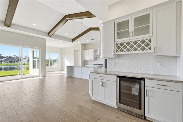 a view of a kitchen with a sink and dishwasher with wooden floor