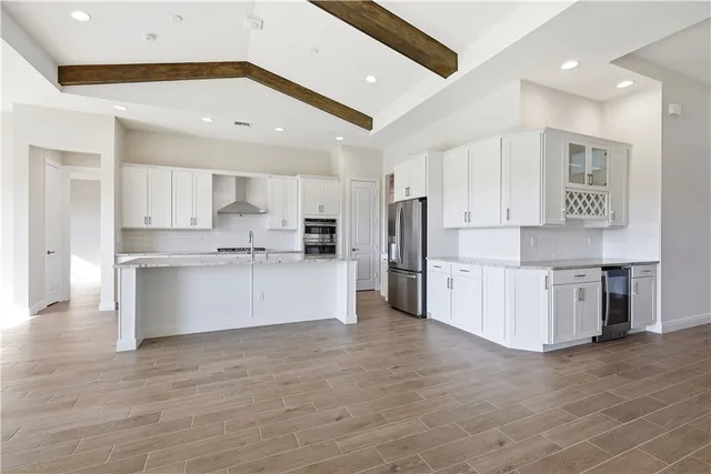 a large kitchen with stainless steel appliances cabinets a sink and a counter top space
