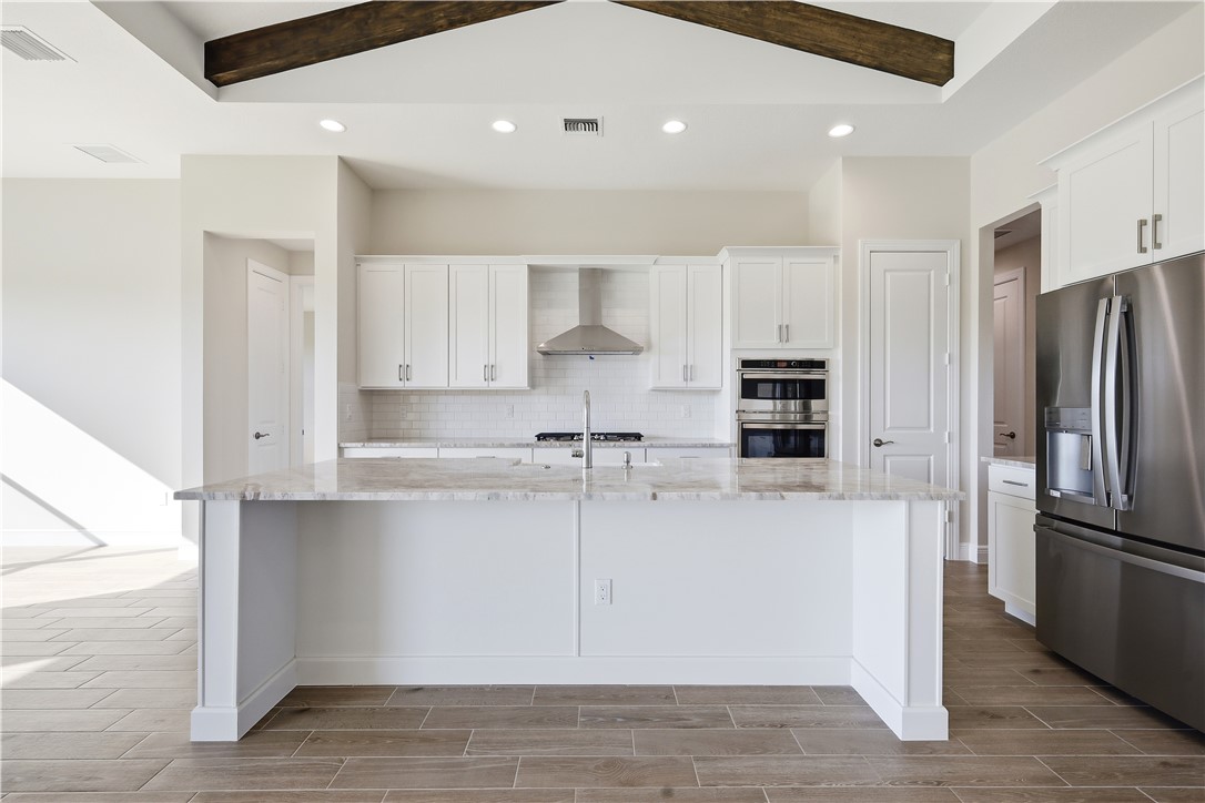 6304 High Pointe Circle Vero Beach, FL 32967 - Photo 6 of 25 a kitchen with stainless steel appliances a refrigerator and a stove top oven