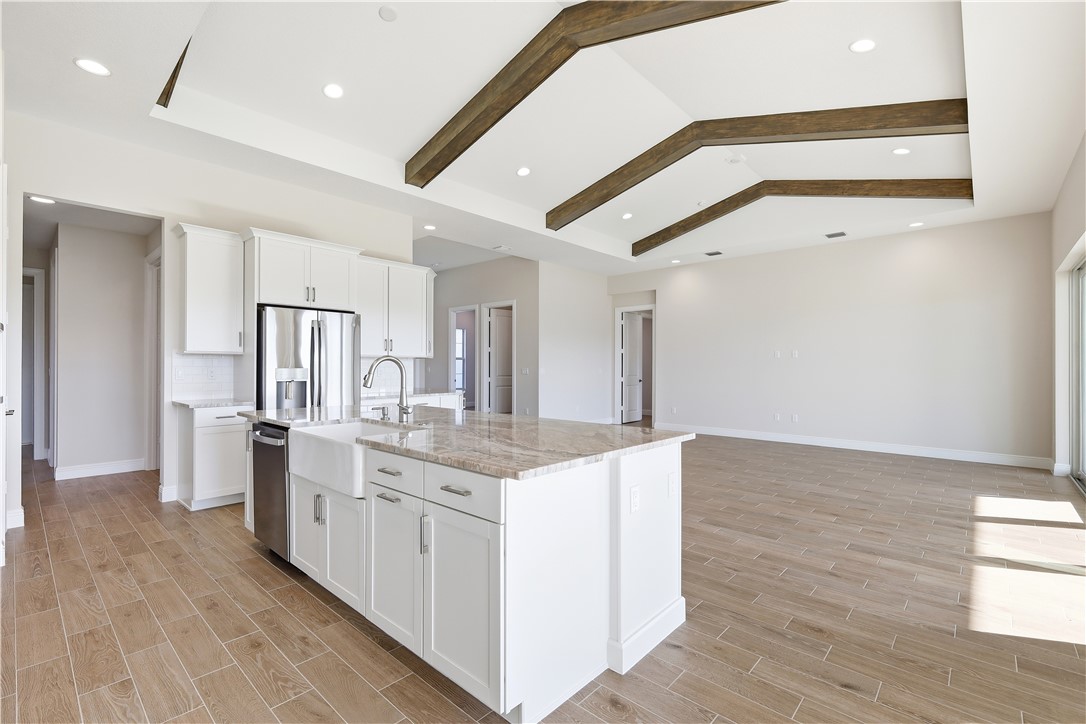 6304 High Pointe Circle Vero Beach, FL 32967 - Photo 8 of 25 a kitchen with stainless steel appliances kitchen island granite countertop a stove and a refrigerator