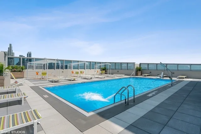 a view of swimming pool with outdoor seating and city view