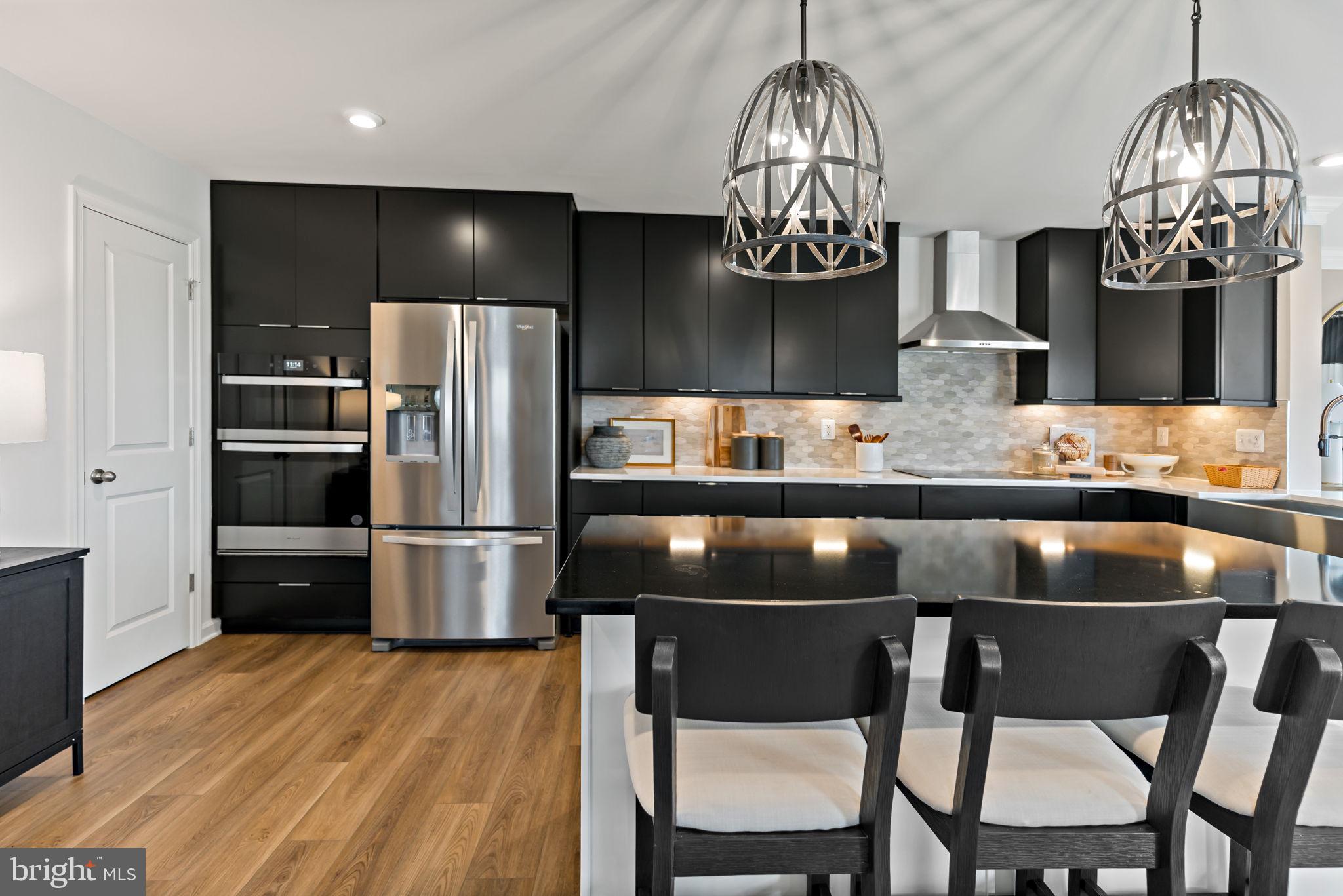 Tbb Tbb Outrigger Road, Unit CARNEGIE Inwood, WV 25428 - Photo 12 of 60 a kitchen with stainless steel appliances granite countertop a table chairs and wooden floor