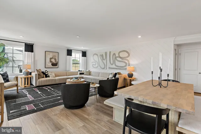 a living room with furniture a rug and a dining table