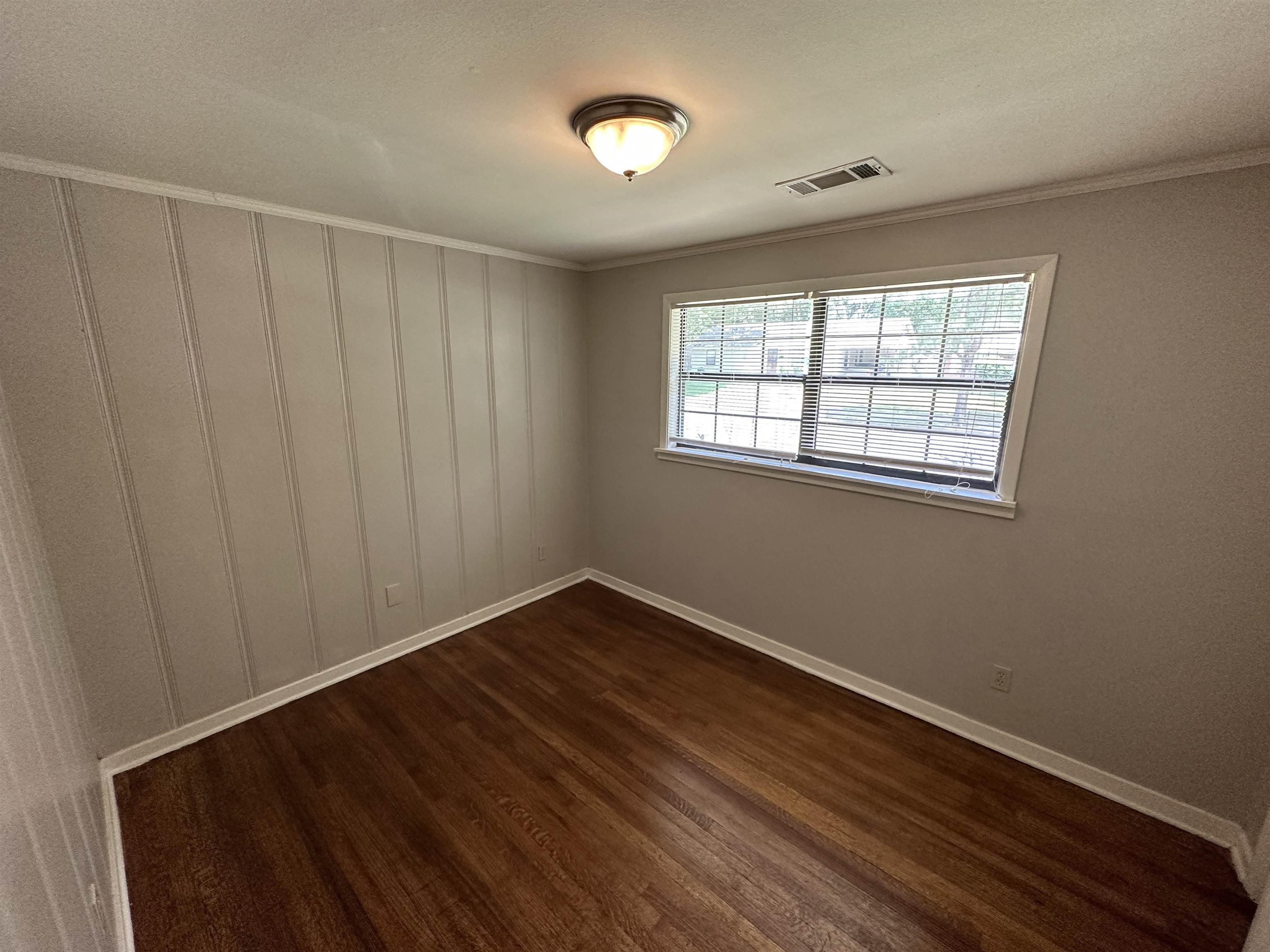 1203 Wilbec Road Memphis, TN 38117 - Photo 13 of 18 a view of an empty room with wooden floor and a window
