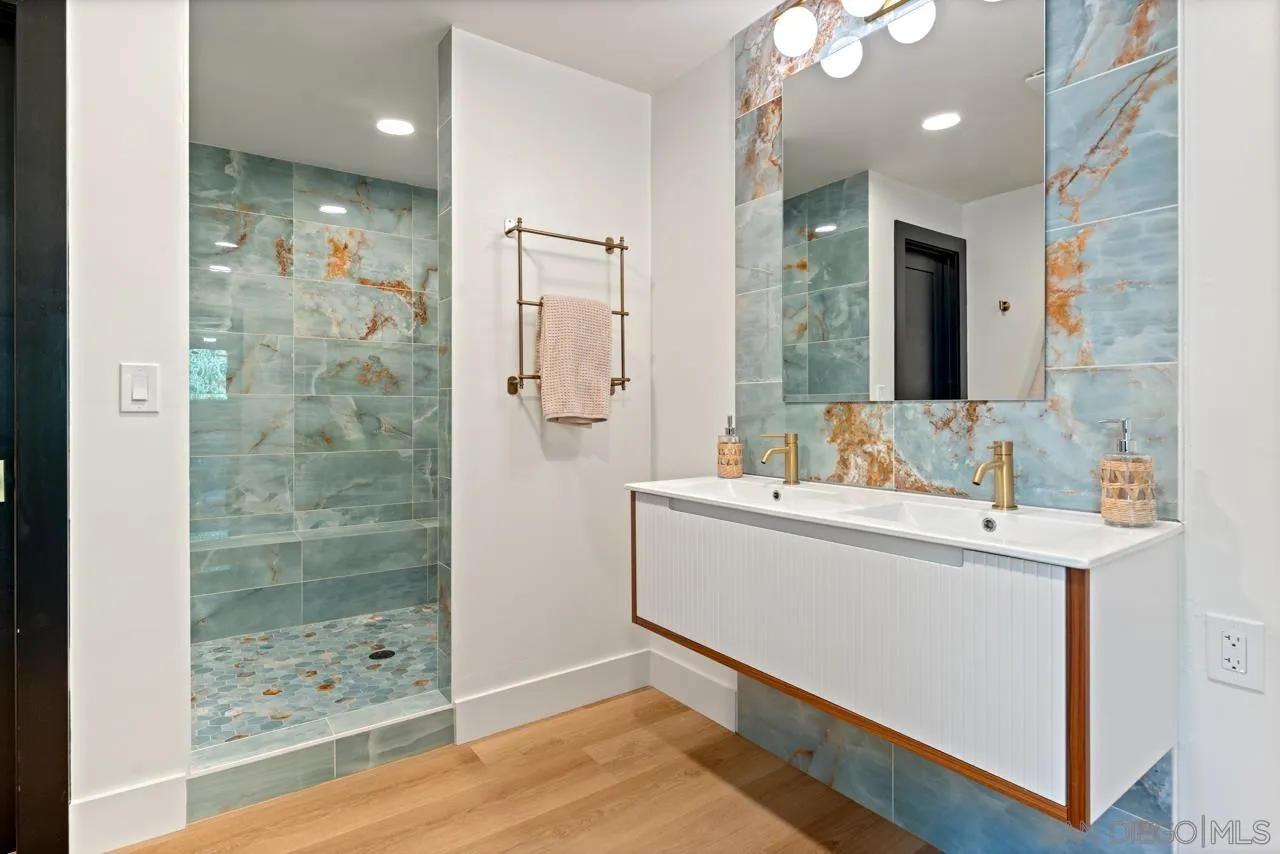 4911 Beaumont Drive La Mesa, CA 91941 - Photo 55 of 74 a bathroom with a shower sink and mirror