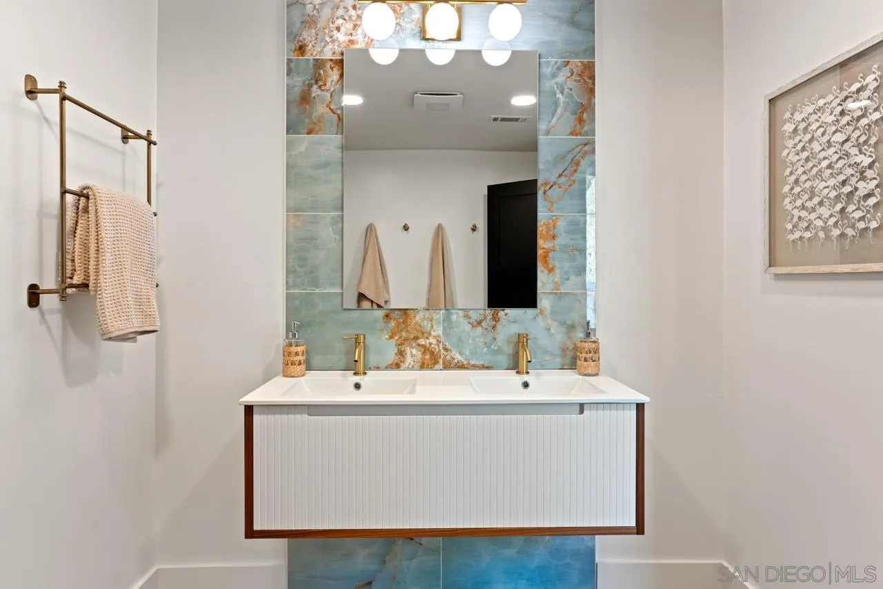 4911 Beaumont Drive La Mesa, CA 91941 - Photo 56 of 74 a bathroom with a sink a mirror and a light fixture
