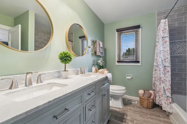 a bathroom with a granite countertop toilet a sink and a mirror