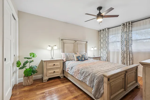 a bedroom with a bed chandelier and a window