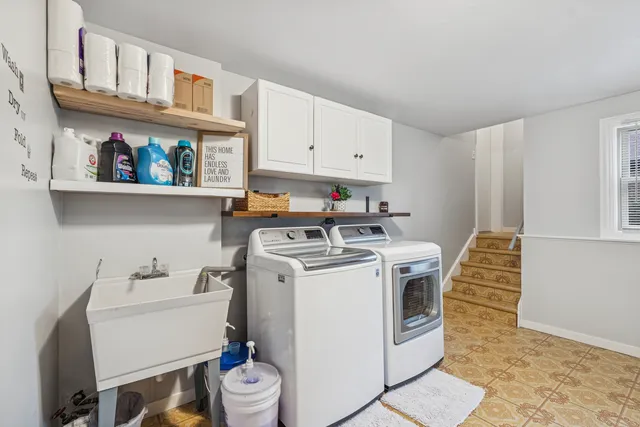 a utility room with dryer washer and a view of living room