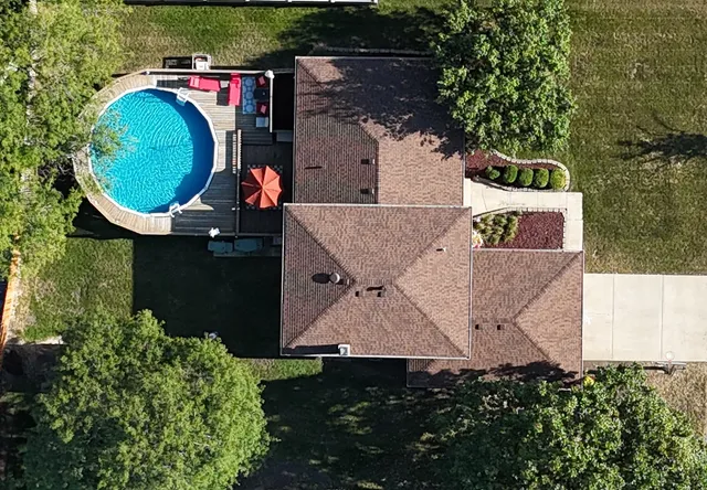 an aerial view of a house with swimming pool and garden