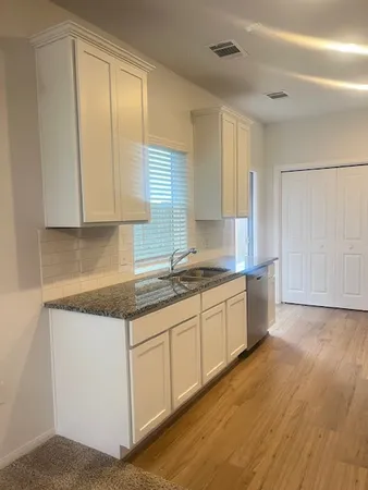 a view of a kitchen with a sink and cabinets