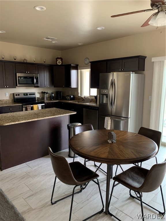 3574 North Kenneth Road Kingman, AZ 86409 - Photo 7 of 20 a kitchen with stainless steel appliances granite countertop a dining table chairs refrigerator and cabinets