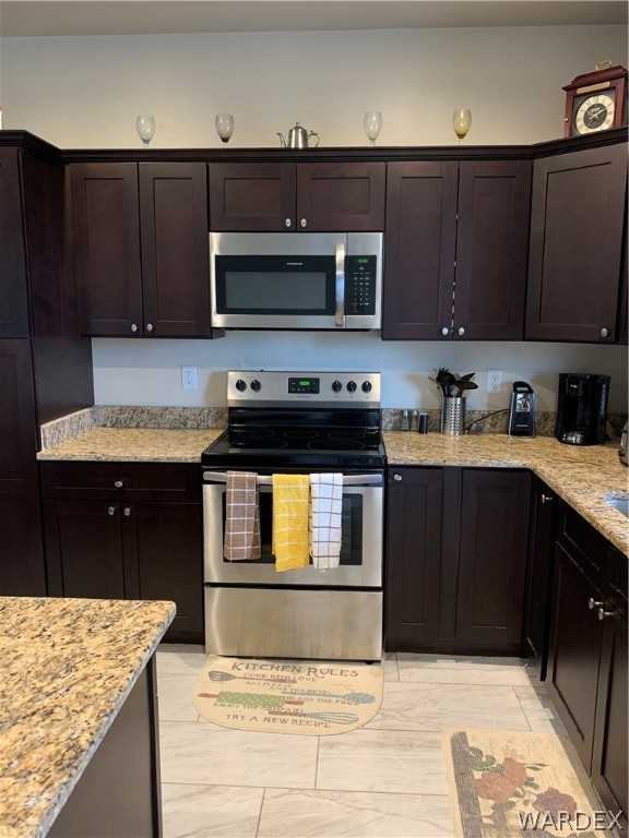 3574 North Kenneth Road Kingman, AZ 86409 - Photo 8 of 20 a kitchen with stainless steel appliances granite countertop a stove and a microwave