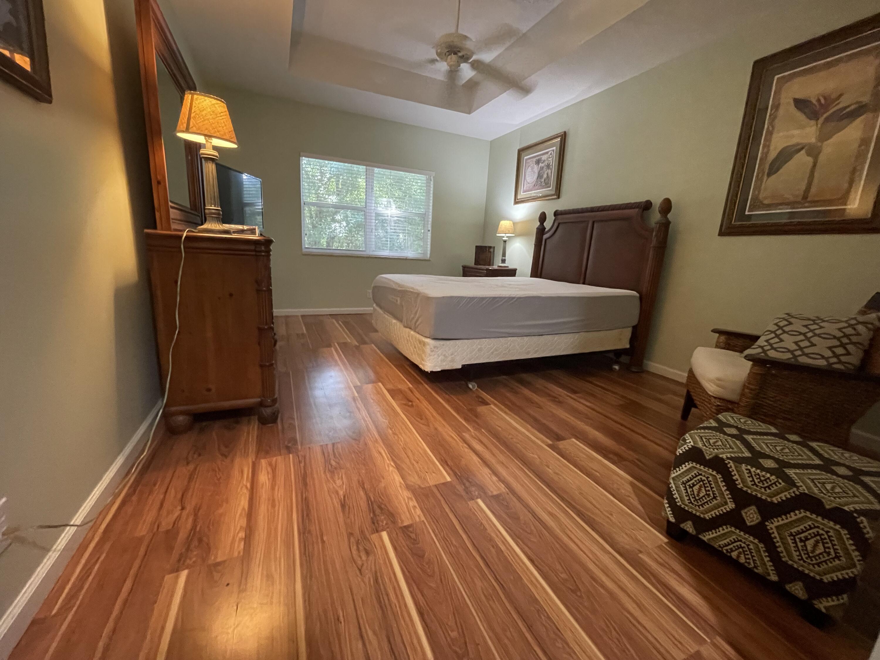 9125 Sand Shot Way, Unit A Port St. Lucie, FL 34986 - Photo 11 of 22 a bedroom with a bed and wooden floor