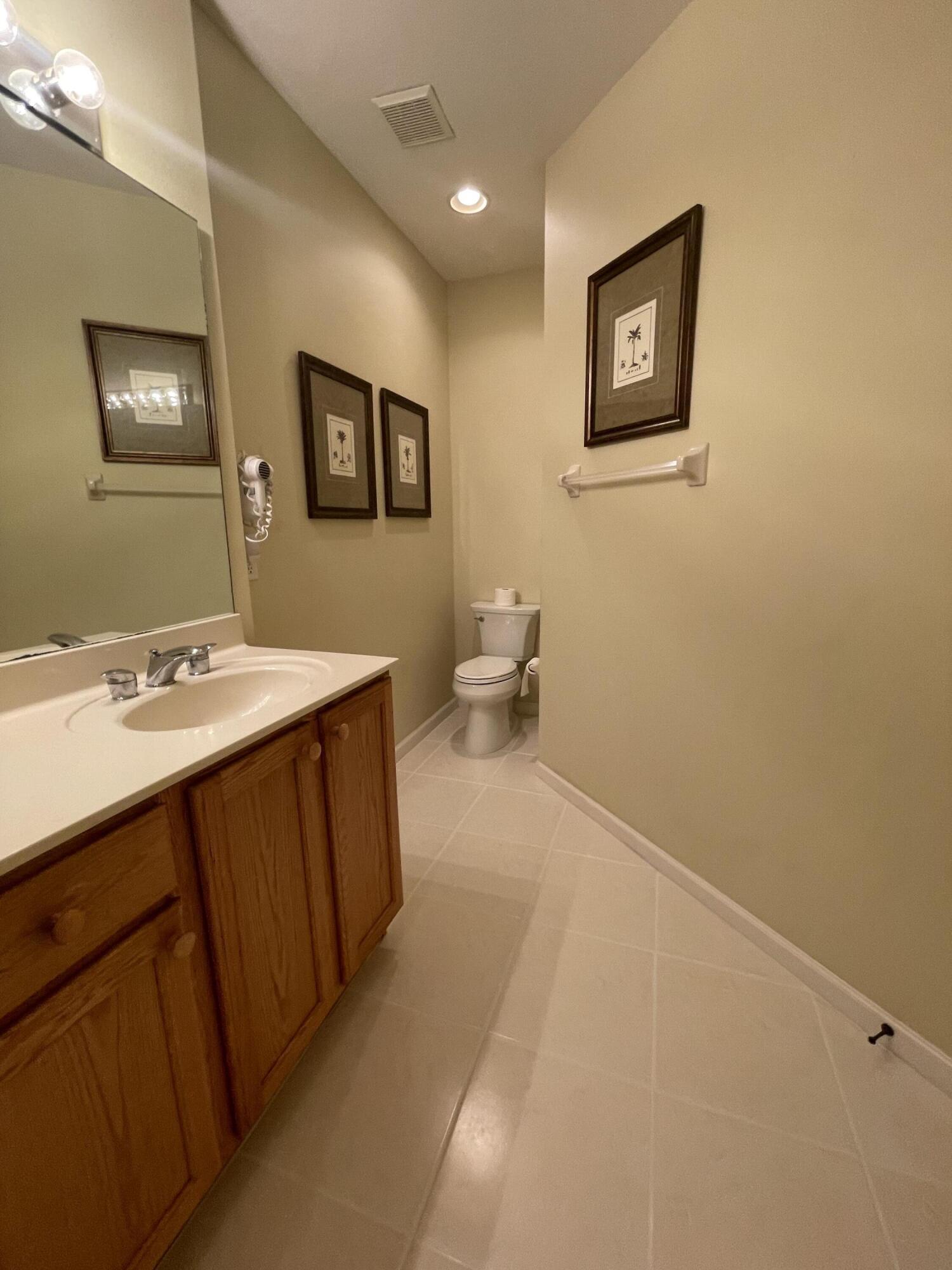 9125 Sand Shot Way, Unit A Port St. Lucie, FL 34986 - Photo 15 of 22 a spacious bathroom with a double vanity sink and a mirror