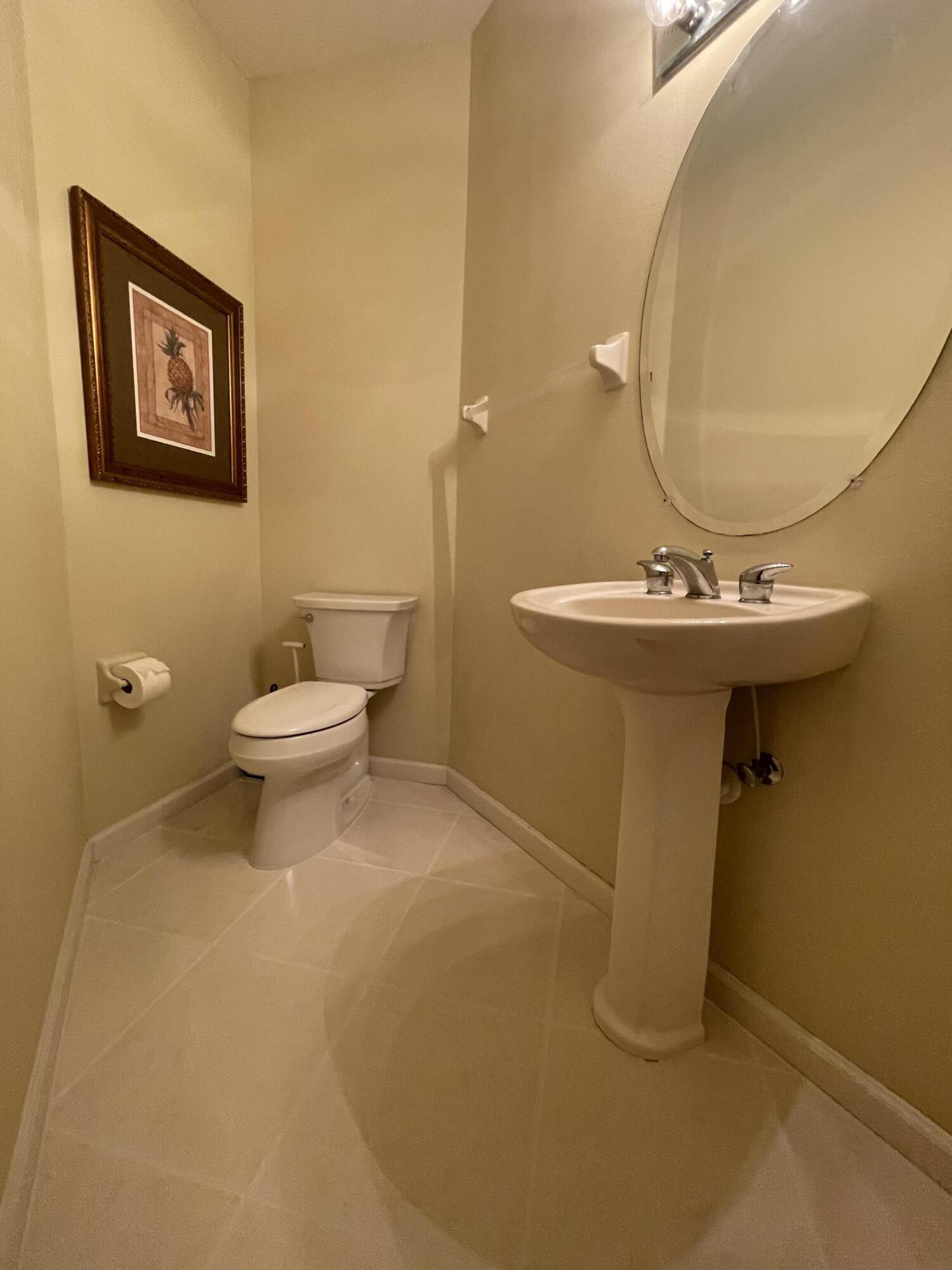9125 Sand Shot Way, Unit A Port St. Lucie, FL 34986 - Photo 17 of 22 a bathroom with a sink mirror and toilet