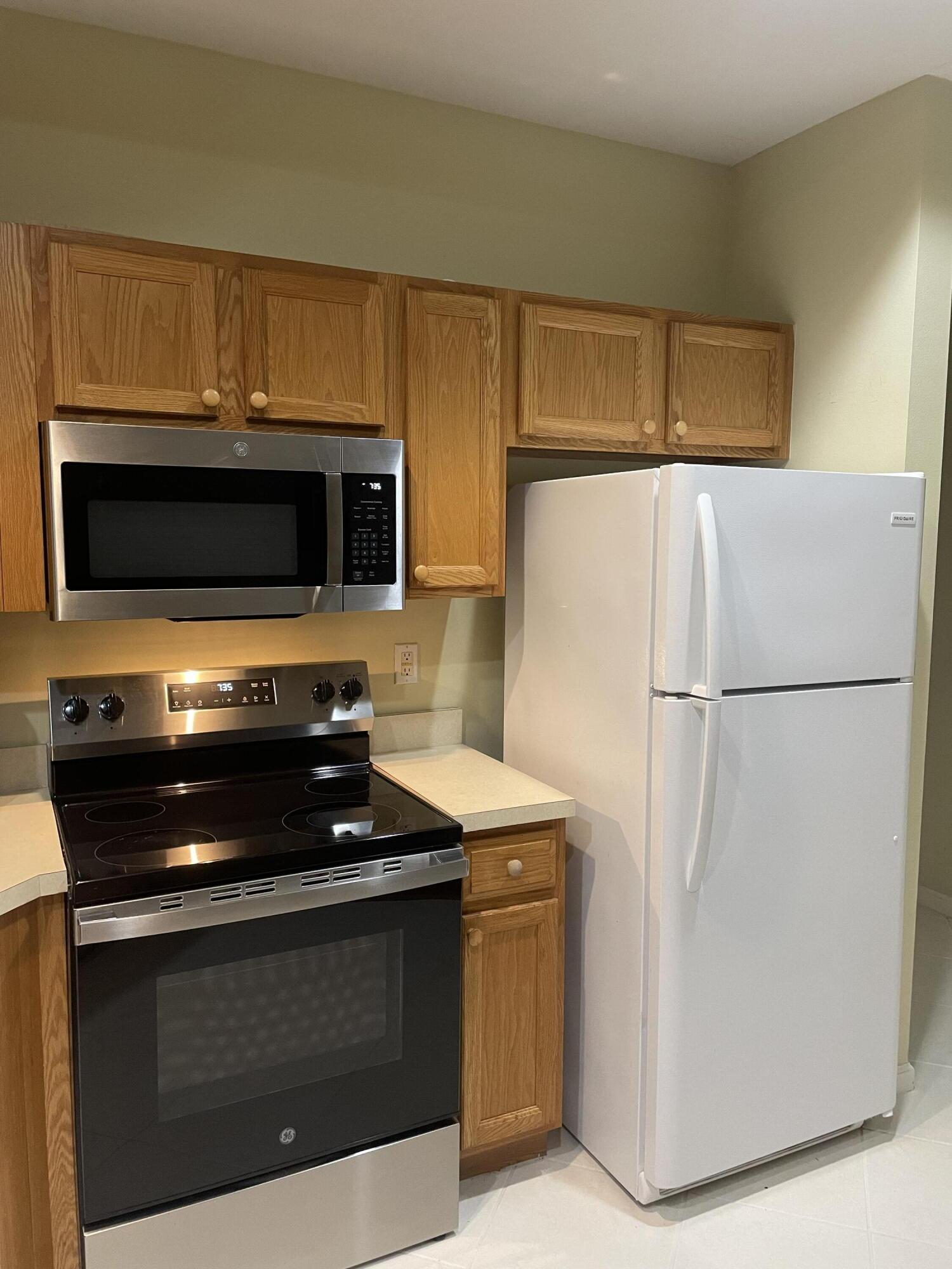 9125 Sand Shot Way, Unit A Port St. Lucie, FL 34986 - Photo 5 of 22 a kitchen with stainless steel appliances a stove a microwave and a refrigerator