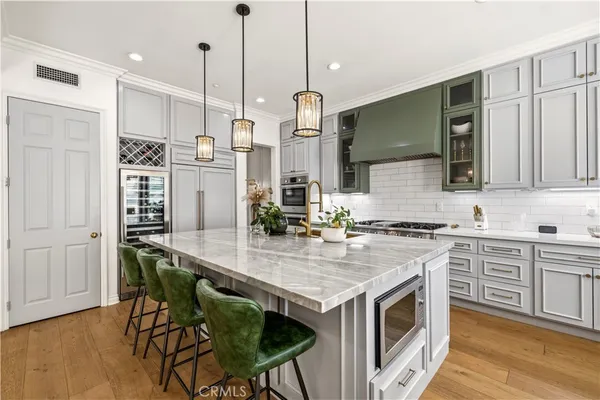 a kitchen with stainless steel appliances granite countertop a sink a stove and a wooden floors