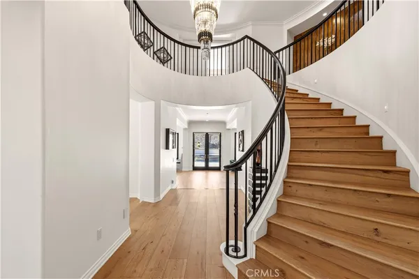 a large bed sitting in a bedroom next to a window and a chandelier