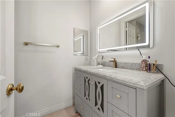 a bathroom with a granite countertop sink a toilet and a mirror