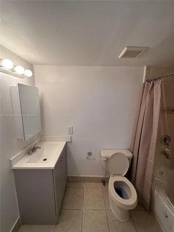 a white toilet sitting next to a shower