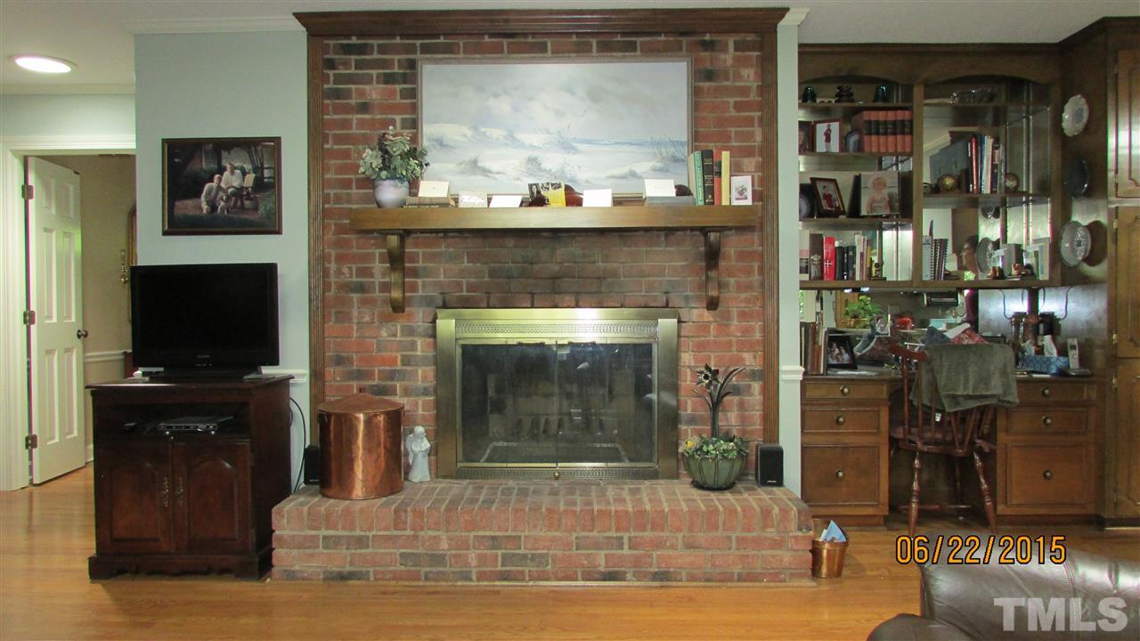 1716 Westhaven Drive Raleigh, NC 27607 - Photo 8 of 22 Family room with hardwood floors, fireplace, built-in bookcase and desk