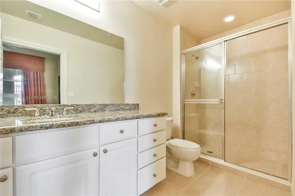 a bathroom with a granite countertop sink tub shower and a mirror