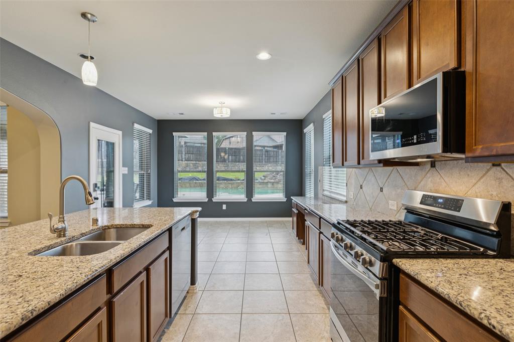 6518 Dry Farm Rowlett, TX 75089 - Photo 11 of 40 a kitchen with a sink stove top oven and granite counter top