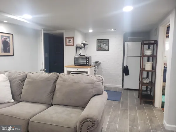 a living room with furniture and a refrigerator