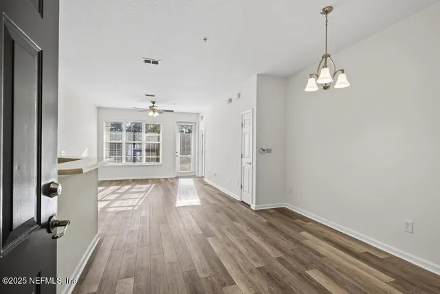 a view of wooden floor and chandelier in a room
